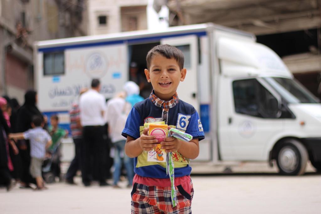 A child holds medicine he received from health workers at a mobile health clinic in a neighbourhood of eastern Aleppo, Syria.