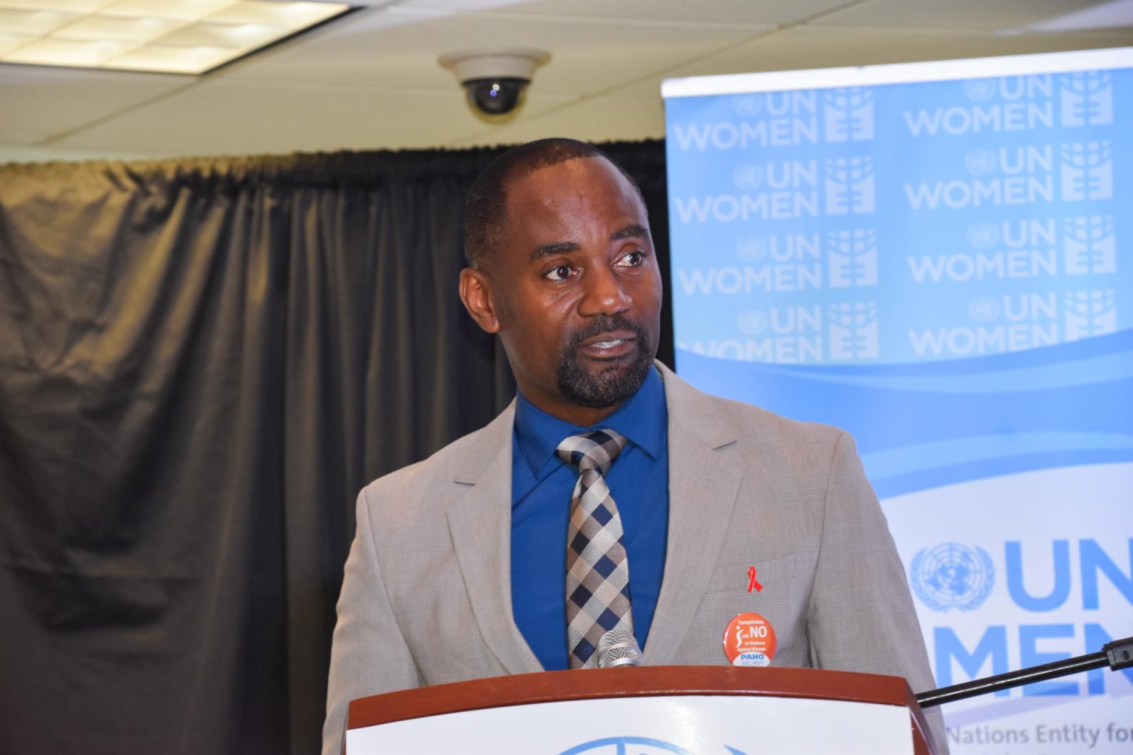 Minister of People Empowerment and Elder Affairs, The Hon.  Kirk Humphrey delivering the Feature Address at the Sunset Lighting Ceremony to observe 16 Days of Activism Against Gender-based Violence.