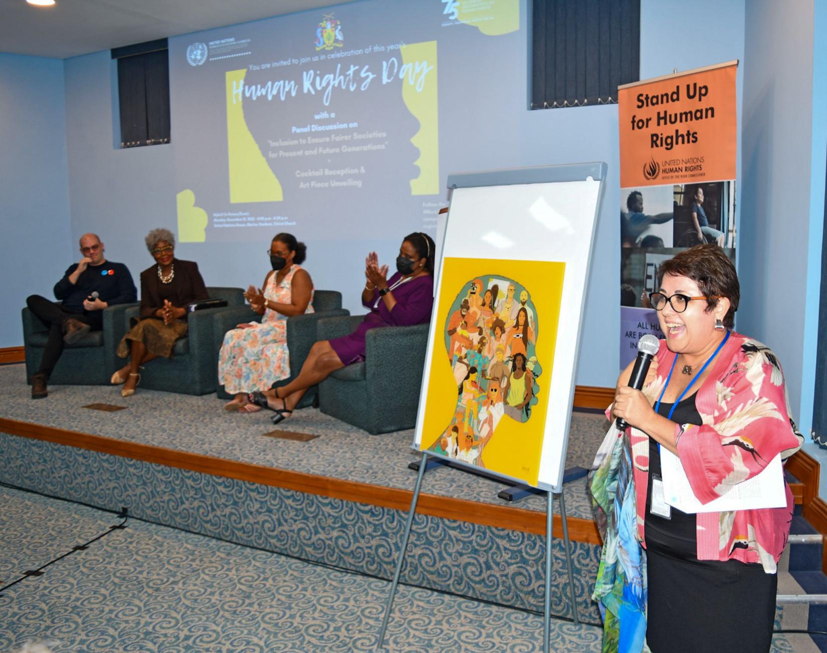 Surprise! Juana Sotomayor, Human Rights Advisor to the RCO for Barbados and the Eastern Caribbean speaks to the audience with glee, moments after unveiling the specially commissioned Human Rights Day piece, created by Painter Alisha Smith. 
