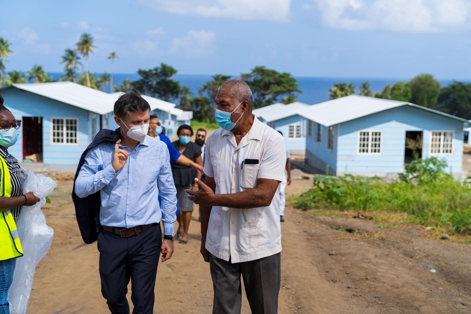 Six months after the eruption, Didier Trebucq, left, with Saint Vincent and the Grenadines Deputy Prime Minister Montgomery Daniel, right, visits a site where nearly 70 family homes are being built.