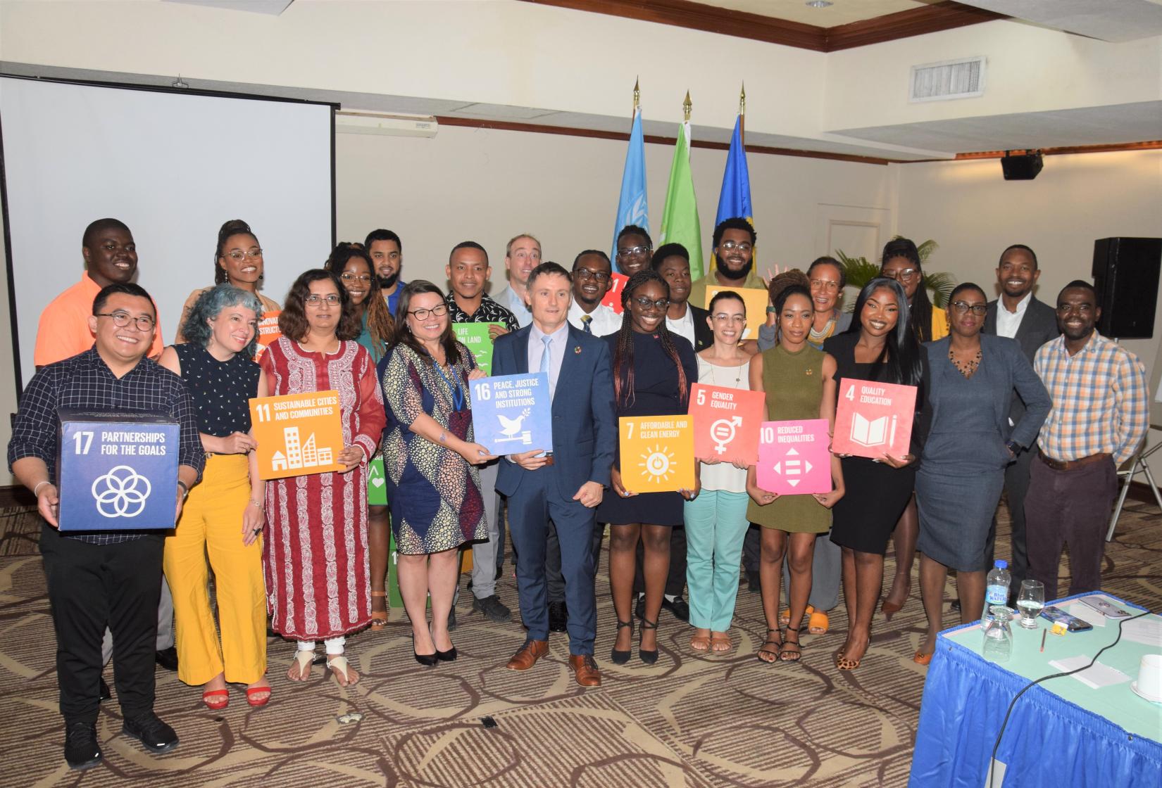 Group photo of smiling young adults holding SDG cards