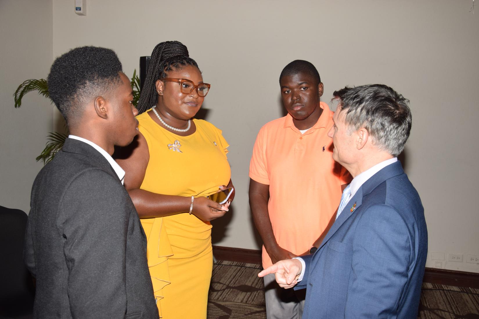 Four adults standing in conversation 