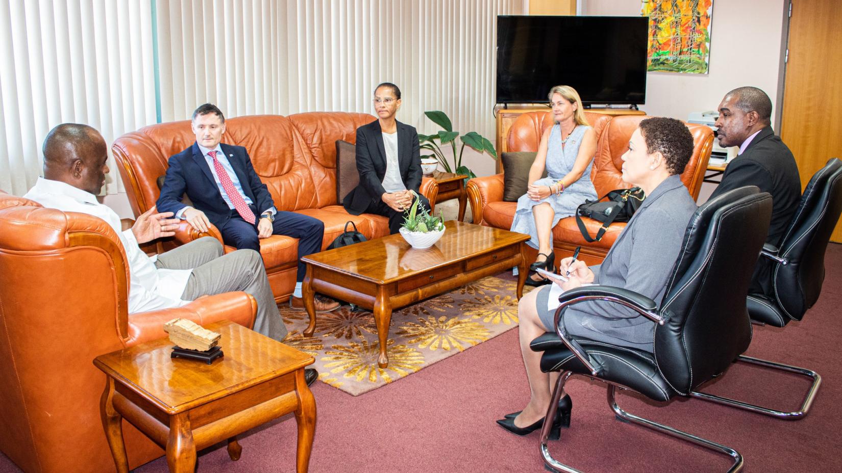 small group of people sitting around a room facing a man in a chair 