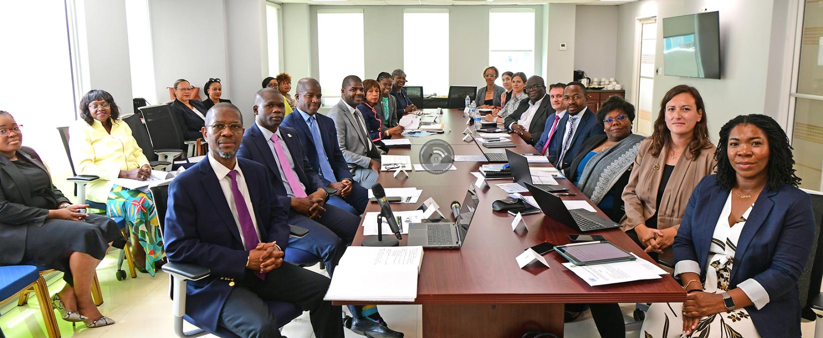 Group of UN and BVI government officials sitting at two sides of a long mahogany table