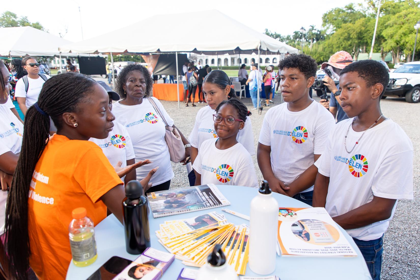 Participants of the SDG Walkathon receive information about the work the UN is doing in Suriname at the UNFPA information booth.