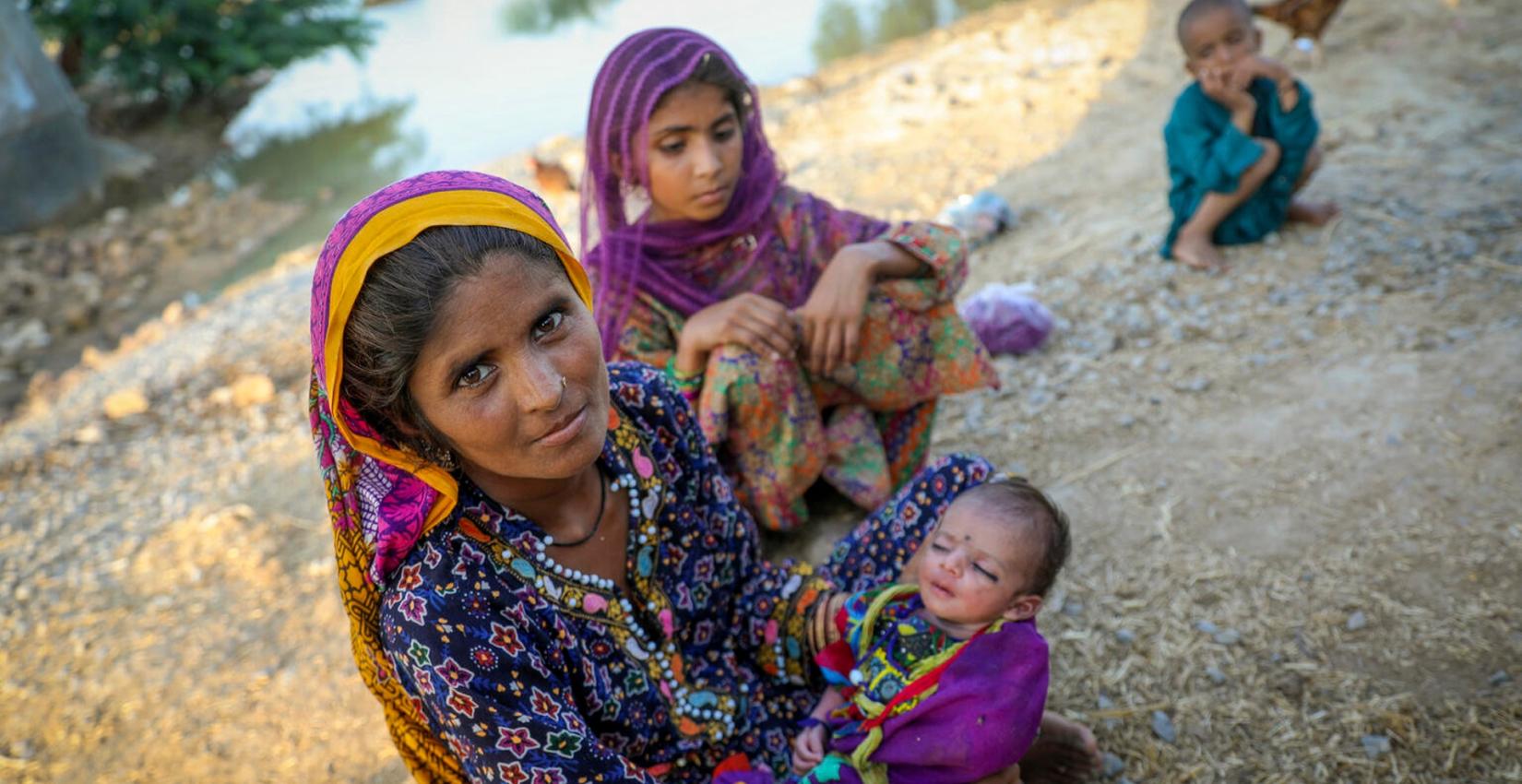 A mother of four children sitting next to flood water, after fleeing their flood hit home. She and her family have taken refuge on the roadside in Jacobabad district, Sindh Province, Pakistan.