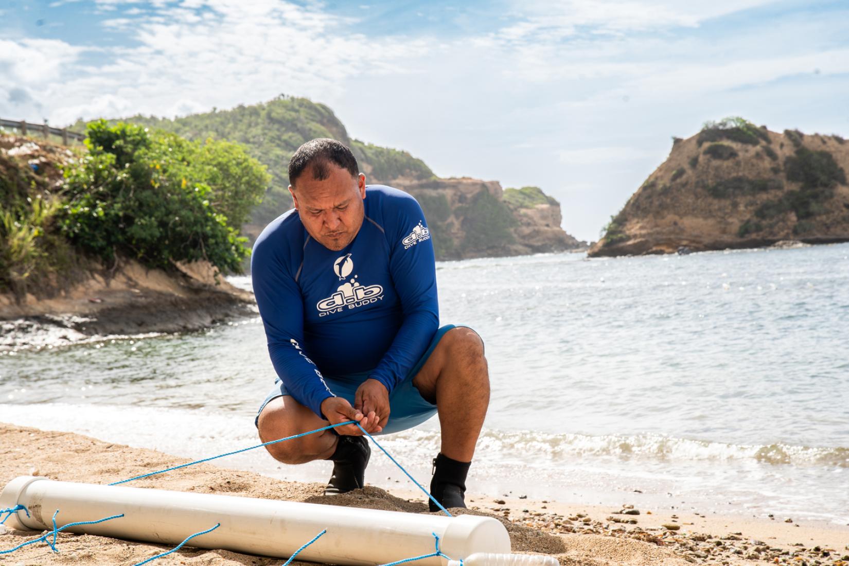 A man tying a rope on a beach