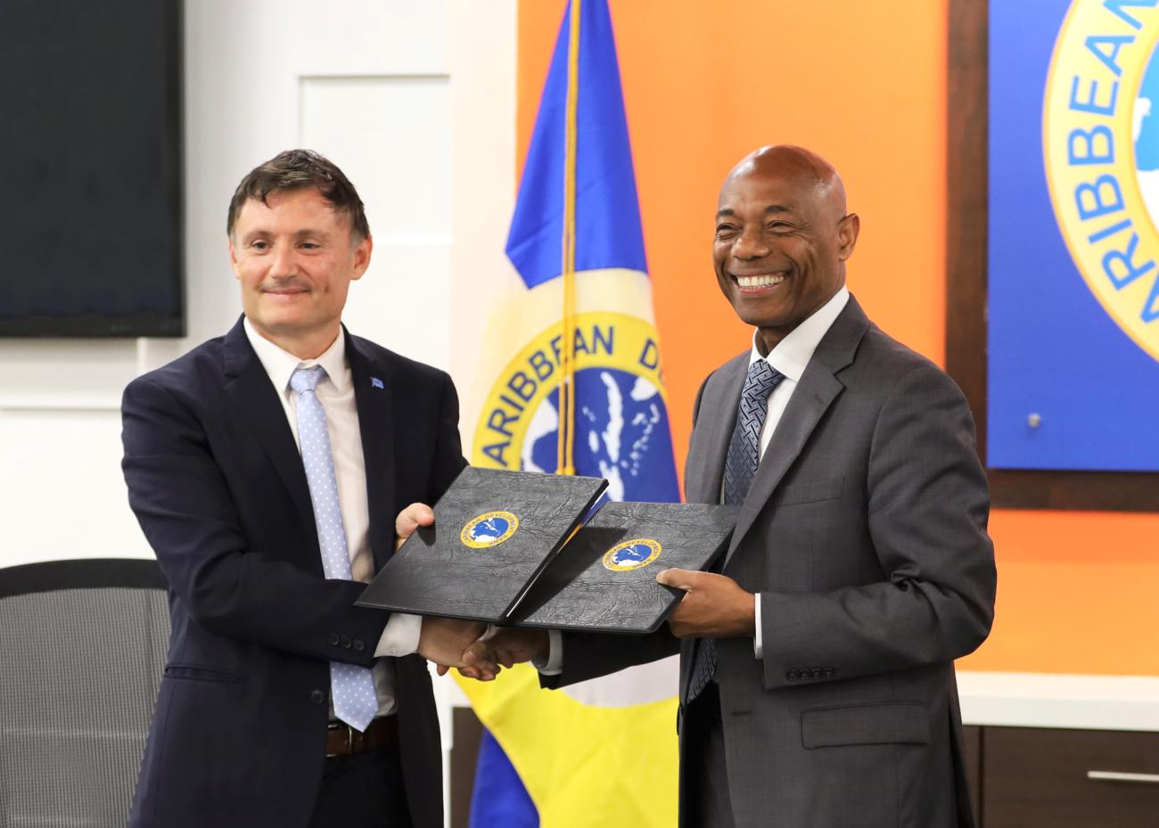 UN Resident Coordinator for Barbados and the Eastern Caribbean Didier Trebucq, and President of the Caribbean Development Bank Dr. Hyginus 'Gene' Leon exchanging signed Letters of Intent at the signing ceremony. 