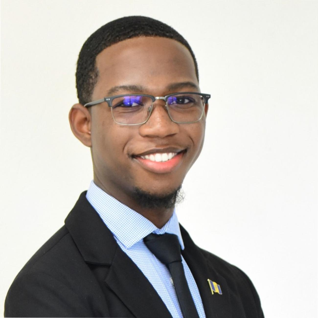 headshot image of a young man in a tie smiling 