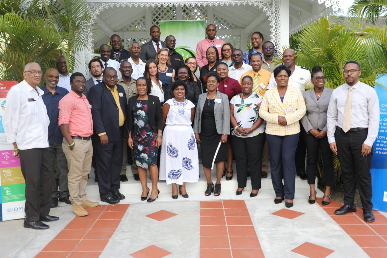 Group photo of men and women standing in a courtyard, smiling for the photo