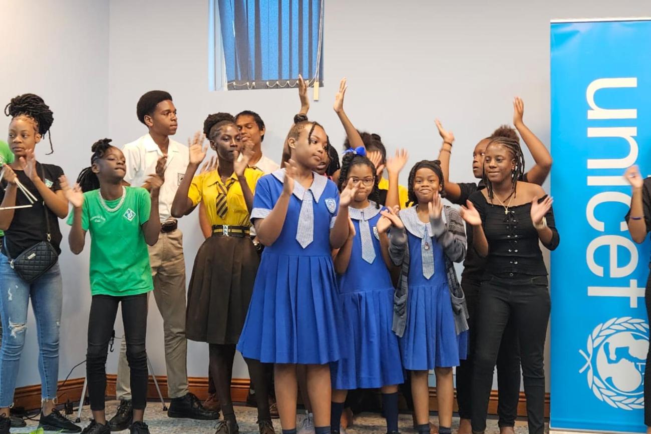 young school girls in uniform raise their hands to clap with smiles