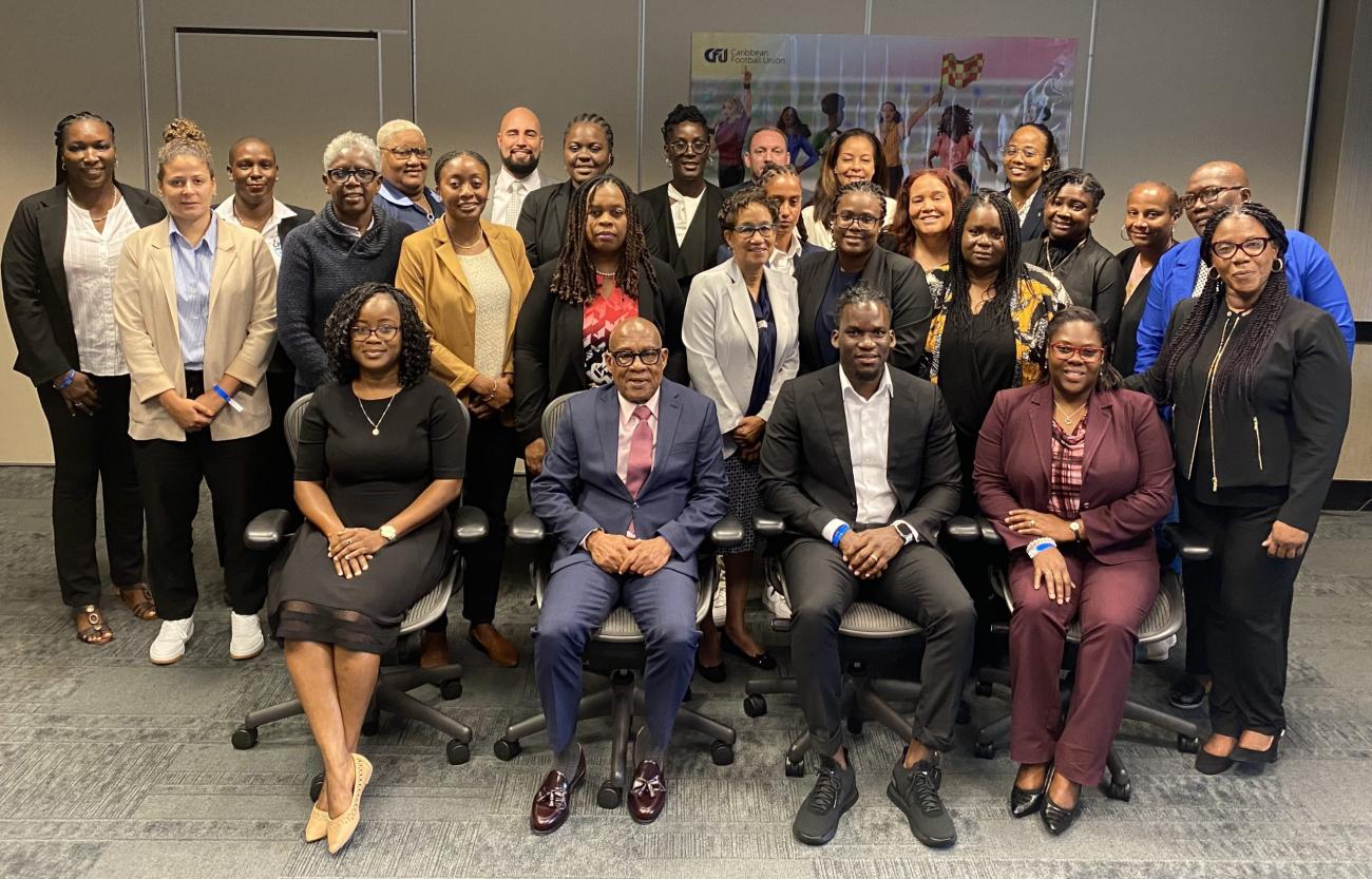 Workshop participants from across the Caribbean sit and stand for a group photo