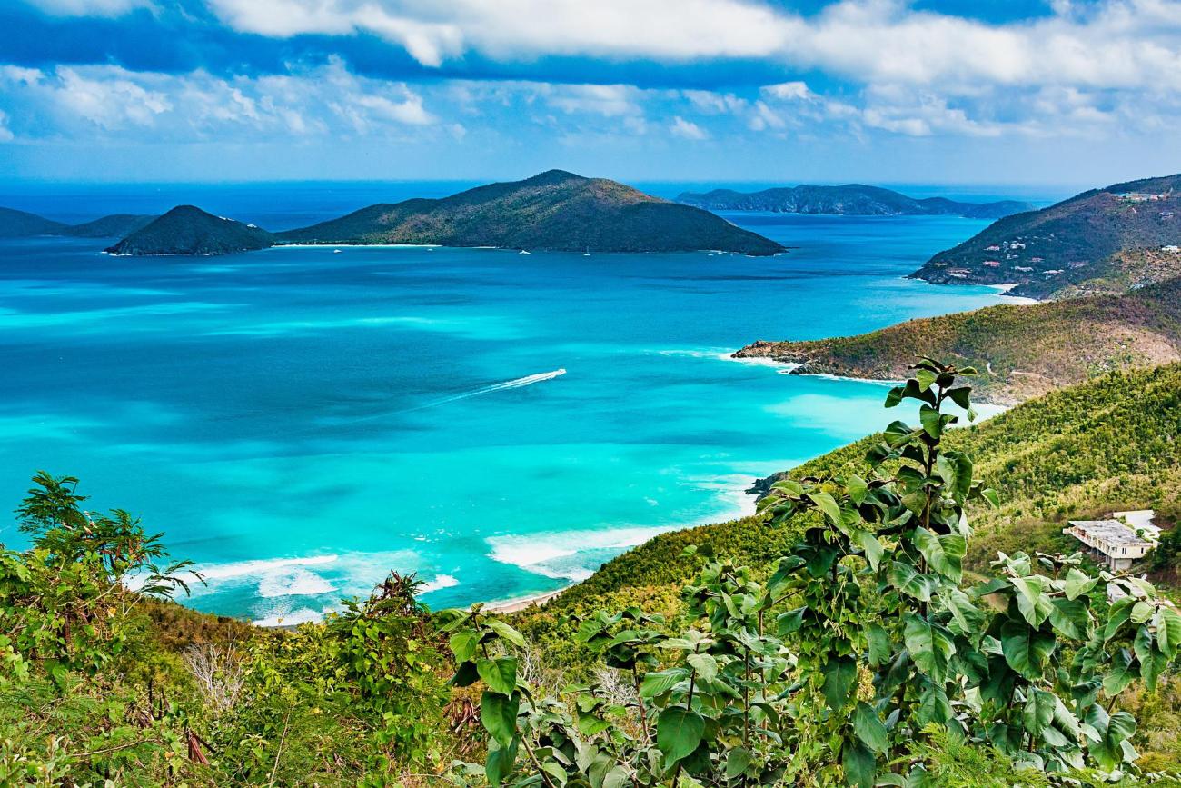 a mountain view of beautiful blue water in a bay, with islands in the distance