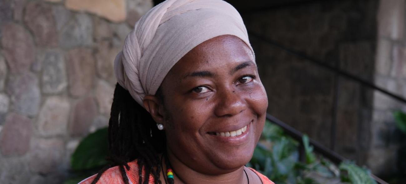 A smiling woman wearing a head scarf