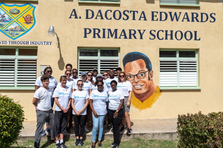 A group of people posing for a photo in front of a school
