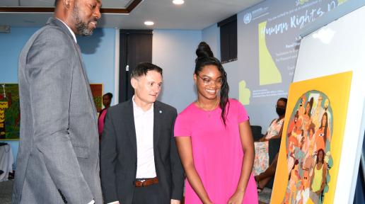 Minister of Labour, Social Security and the Third Sector, the Honourable Colin Jordan, UN Resident Coordinator for Barbados and the Eastern Caribbean, Didier Trebucq, and Painter, Alisha Smith, discuss her specially commissioned artwork during the 2022 Human Rights Day Event.