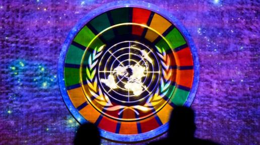 SDG Wheel Symbol on a screen, with the UN Seal imposed atop it on a projection