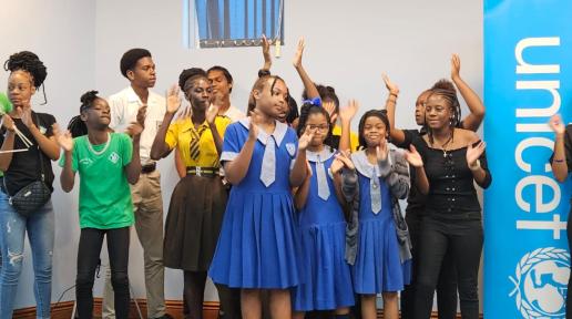 young school girls in uniform raise their hands to clap with smiles