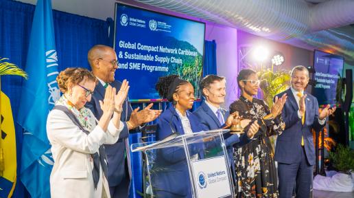 A group of people stand together applauding in front of a podium