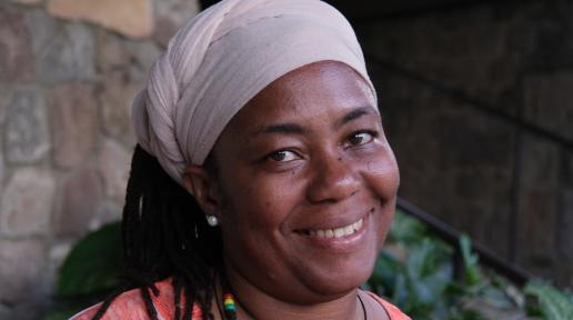 A smiling woman wearing a head scarf
