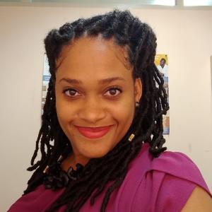 grinning portrait of woman with braided hair and red lipstick