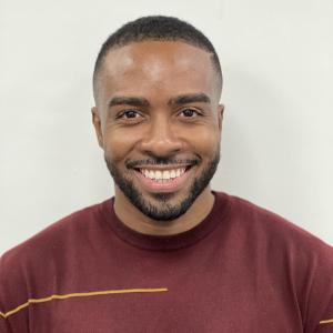 portrait of smiling man in burgundy shirt on a white background