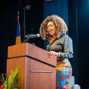 Woman standing behind podium addressing an audience