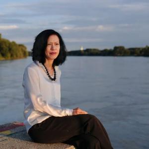 A person sitting on a ledge by a body of water