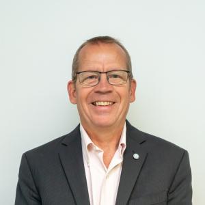 Photo of man in suit and glasses smiling